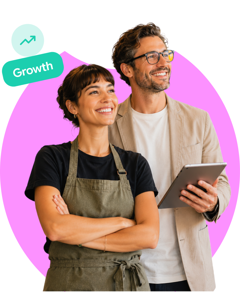 Two small business owners smiling while reviewing social media growth on a tablet